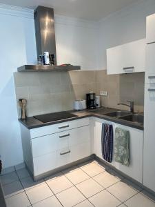 a kitchen with white cabinets and a sink at Appartement cosy Guidel centre in Guidel