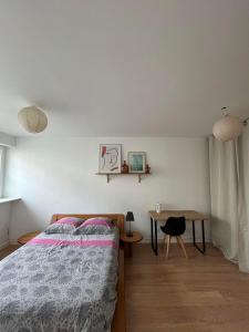 a bedroom with a bed and a table at Appartement cosy Guidel centre in Guidel