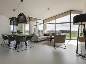 een woonkamer met een bank, een tafel en stoelen bij Cottage in Wissenkerke near Banjaard Beach in Wissenkerke