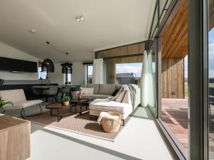 een woonkamer met een bank en een tafel bij Cottage in Wissenkerke near Banjaard Beach in Wissenkerke