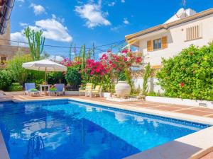 a swimming pool in front of a house with flowers at Can Nicolau - Villa With Private Pool In Colònia De Sant Pere Free Wifi in Colonia de Sant Pere