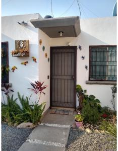 a white house with a brown door at Casita práctica, sencilla y lista para recibirte. in Silao
