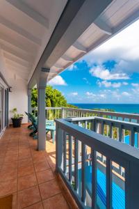 a balcony with a view of the ocean at Hodges Bay House in Calibishie
