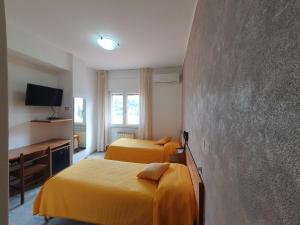 Habitación de hotel con 2 camas y pared en Hotel Ristorante Supersonik, en Acri