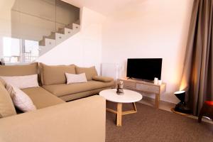 a living room with a couch and a tv at Summer Villa Barbara ,private pool in Mikonos