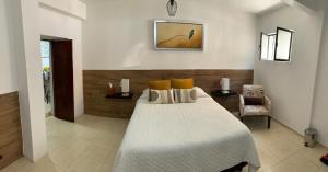 a bedroom with a large white bed with yellow pillows at Casa Don Agus in Guanajuato