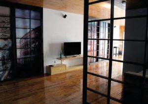 sala de estar con TV y suelo de madera en Departamento en Casa Azul centro de SLP con jacuzzi y terraza - INMOTEGA, en San Luis Potosí