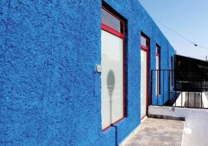 サン・ルイス・ポトシにあるDepartamento en Casa Azul centro de SLP con jacuzzi y terraza - INMOTEGAの窓とバルコニー付きの青い建物