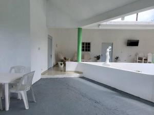 una habitación blanca con una mesa y una estatua en ella en Villa sonia, en Juan Barón