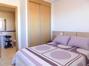 ein Schlafzimmer mit einem Bett mit lila Kissen in der Unterkunft Playa Ribera MED007 in La Estación + 15 Fotos