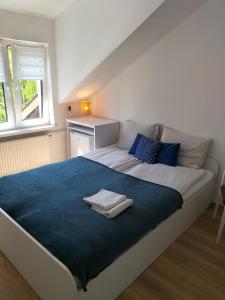 a bedroom with a large bed with a blue blanket at Pokoje i apartamenty Mak in Łeba