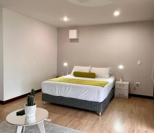 a bedroom with a large bed and a table at Hotel Rioverde in Rionegro