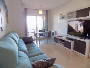 ein Wohnzimmer mit Sofa und Flachbildfernseher in der Unterkunft Playa Ribera MED007 in La Estación
