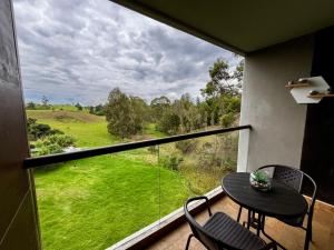 a balcony with a table and chairs and a view of a field at Hotel Rioverde in Rionegro