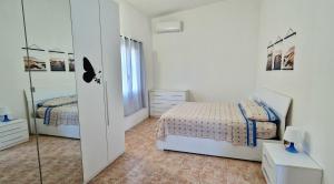 a white bedroom with two beds and a mirror at Via del Mare in Termoli +33 photos