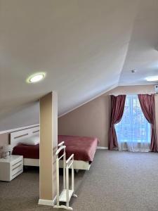 Schlafzimmer mit einem Bett und einem Fenster in der Unterkunft Hotel Korona in Kropywnyzkyj
