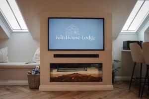 a flat screen tv above a fireplace in a living room at Kiln House Lodge in Harrogate
