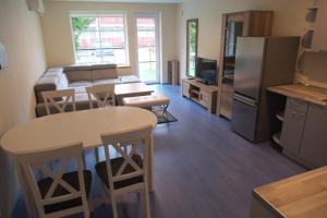 a kitchen and living room with a table and chairs at Kalno Apartamentai in Juodkrantė