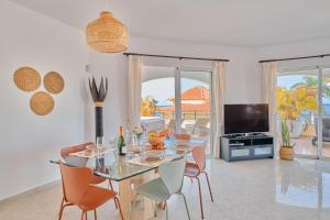 a dining room with a table and chairs and a television at Ocean View Vila with Private Jacuzzi in Los Cristianos