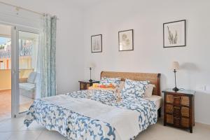 a bedroom with a bed with a blue and white blanket at Ocean View Vila with Private Jacuzzi in Los Cristianos