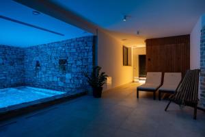 a bathroom with a tub with a stone wall at Nono Ban Hotel & Villa in Gornji Humac