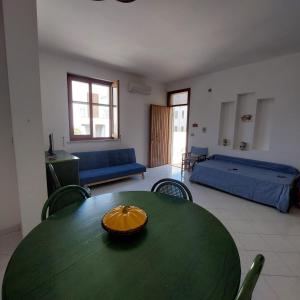een woonkamer met een groene tafel en een bank bij Casa Paco in Favignana