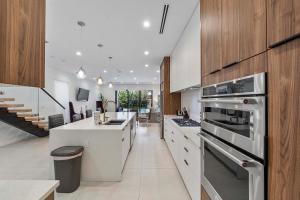 a kitchen with stainless steel appliances and wooden cabinets at Mins to Las Olas Private Pool BBQ Grill Luxurious in Fort Lauderdale