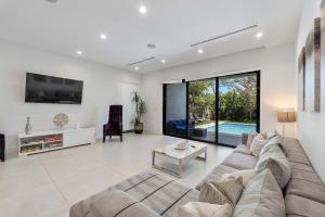 a living room with a large couch and a table at Mins to Las Olas Private Pool BBQ Grill Luxurious in Fort Lauderdale