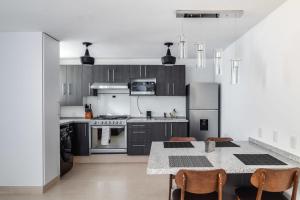 a kitchen with stainless steel appliances and a table with chairs at MS Deslumbrante Suite Centrico A11 in Casa Blanca La Corregidora