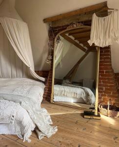 ein Schlafzimmer mit einem Bett und einem Spiegel auf dem Boden in der Unterkunft Les séquoias géants in Saint-Martin-aux-Arbres