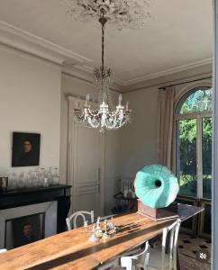 a dining room with a table and a chandelier at Les séquoias géants in Saint-Martin-aux-Arbres