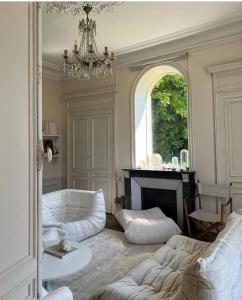 a living room with white furniture and a chandelier at Les séquoias géants in Saint-Martin-aux-Arbres