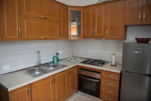 a kitchen with wooden cabinets and a stainless steel refrigerator at Villa Stefano Stepa in Tragjas