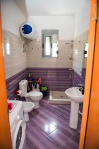 a bathroom with three toilets and two sinks and a mirror at Vila Stefano Stepa in Tragjas