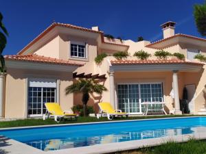 a villa with a swimming pool in front of a house at Villa Terra da Eira-Sea view in Lourinhã