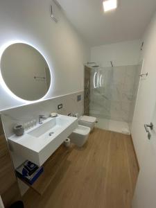 a bathroom with a sink and a toilet and a mirror at Residence Cala Bianca in Porto Torres