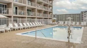 a swimming pool with chairs and a hotel at Quality Inn & Suites Oceanblock in Ocean City