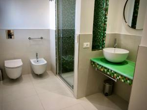 uma casa de banho com um lavatório, um WC e um chuveiro em COCCIU D’AMURI em Castellammare del Golfo