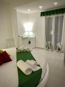 1 dormitorio con 1 cama con toallas en COCCIU D’AMURI en Castellammare del Golfo