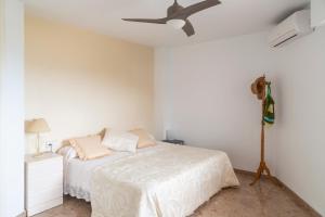 a bedroom with a bed and a ceiling fan at AP Over the Sea in Arenales del Sol +22 photos