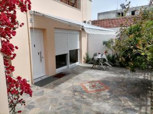 un patio di una casa con tavolo e fiori di Στουντιο Βολος Ν Ιωνια a Volos