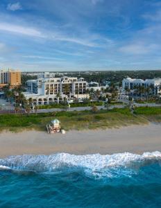 Opal Grand Oceanfront Resort & Spa في ديلراي بيتش: اطلالة جوية على شاطئ به مباني و المحيط