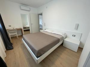 - une chambre blanche avec un lit et une table dans l'établissement Residence Cala Bianca, à Porto Torres