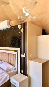 a room with a bed and a bed and a table at RUM JOHARH lUXURY CAMP in Wadi Rum