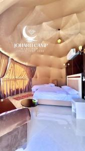 a hotel room with two beds and a table at RUM JOHARH lUXURY CAMP in Wadi Rum