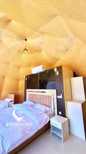 a bedroom with a bed and a yellow ceiling at RUM JOHARH lUXURY CAMP in Wadi Rum