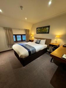 a bedroom with a large bed and a window at Golden Lion Hotel in Rugby