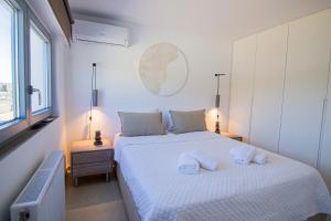 a bedroom with a white bed with two pillows on it at Summer Villa Barbara ,private pool in Mikonos +31 photos