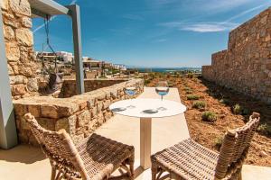 a table with two glasses of wine on a patio at Summer Villa Barbara ,private pool in Mikonos