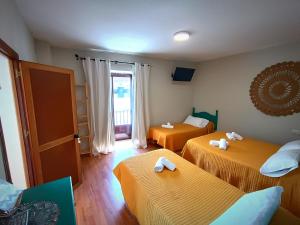Habitación de hotel con 2 camas y toallas. en Hostal Cristina, en Chipiona